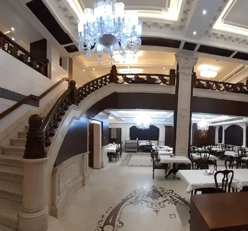 فضای داخلی لوکس و باشکوه رستوران اقدسیه با پلکان مرمرین، لوسترهای کریستالی و سالن غذاخوری بزرگ آماده پذیرایی.