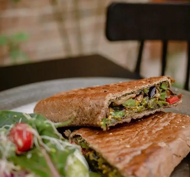 ساندویچ گریل شده (پنینی) سبزیجات تازه و سالم کافه رستوران دایموند با سالاد سبز مخصوص، ایده‌آل برای یک وعده ناهار یا شام دلپذیر.