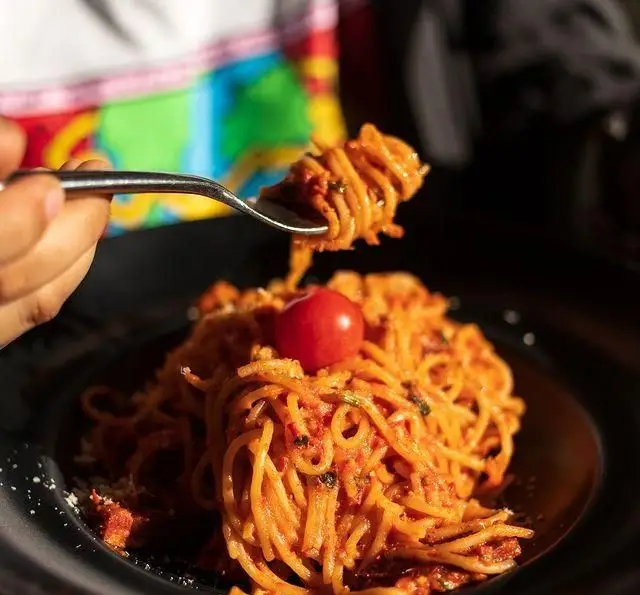 سرو اسپاگتی لذیذ با سس گوجه فرنگی مخصوص و پنیر پارمزان، آماده برای لذت بردن در کافه رستوران دایموند. غذای ایتالیایی عالی.