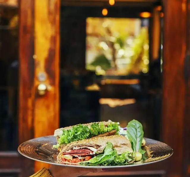 ساندویچ‌های تازه و دلپذیر کافه رستوران دایموند با نان چاودار، گوشت، پنیر، کاهو و گوجه فرنگی، سرو شده روی سینی فلزی.