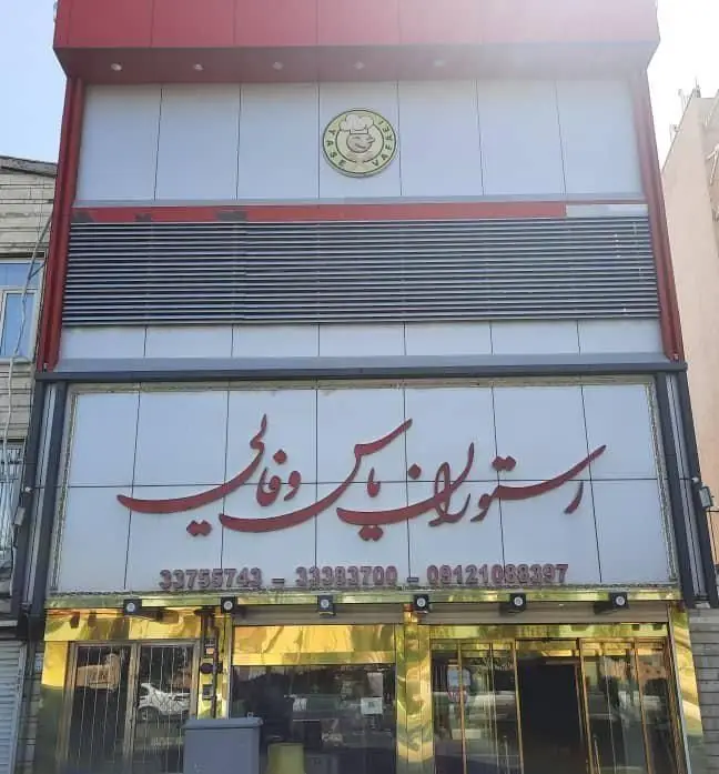 نمای بیرونی رستوران یاس وفایی با تابلوی بزرگ قرمز و لوگوی اختصاصی، شامل شماره تلفن‌ها، آماده ارائه بهترین غذاها.