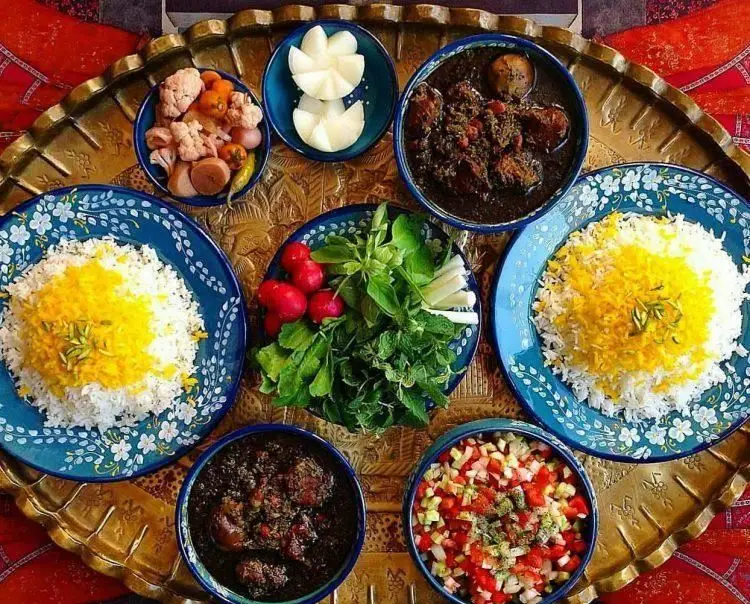 سفره رنگین غذای سنتی و خانگی ایرانی کترینگ رز شامل پلو زعفرانی، خورشت قورمه سبزی و فسنجان با مخلفات لذیذ. سفارش آنلاین غذا.