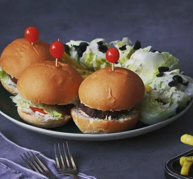 سه مینی برگر (اسلایدر) جذاب با نان تازه، سبزیجات و سس مخصوص، در کنار سالاد و سیب زمینی سرخ کرده کافه خانه فرهنگ و هنر سرهنگ.