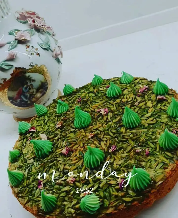کیک پسته مجلسی و خوشمزه از هنرکده کارامل با تزئین زیبای خلال پسته، مرنگ سبز و گل محمدی. دسری خاص و دلپذیر برای مهمانی ها.