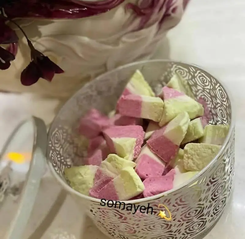 کاسه‌ای زیبا از مارشمالوهای دست‌ساز هنرکده کارامل در رنگ‌های شاد صورتی و سبز، انتخابی عالی برای دسر و پذیرایی.