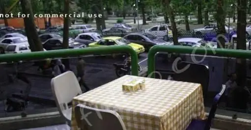 فضای باز دلنشین فست فود پترو با میز و صندلی شطرنجی و منظره‌ای از خیابان پر جنب و جوش. مکانی عالی برای صرف یک وعده غذایی.