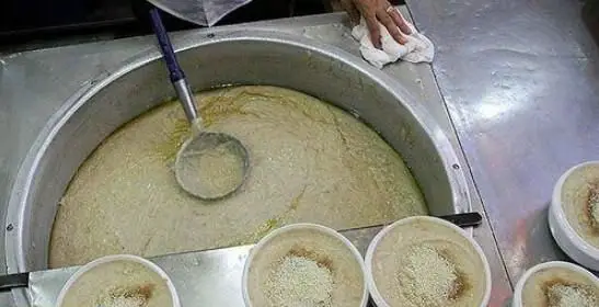 آش و حلیم پزی حاج علی معنوی و پسران: سرو حلیم داغ و تازه از دیگ بزرگ به کاسه‌های آماده مشتریان با کیفیت عالی.