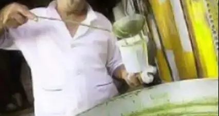 تهیه و سرو حلیم اصیل و باکیفیت حاج علی معنوی و پسران، آشپزی ماهر در حال ارائه بهترین آش و حلیم.