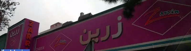تصویری از تابلوی صورتی رنگ فست فود زرین با نام "Zarrin" به خط فارسی و لاتین، هویت بصری جذاب یک رستوران غذای آماده.