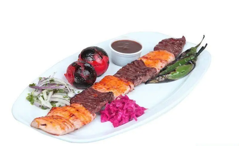 سینی کباب مخلوط رستوران توچال شامل فیله گوساله و ماهی سالمون گریل شده با گوجه، پیاز، فلفل کبابی و ترشی کلم