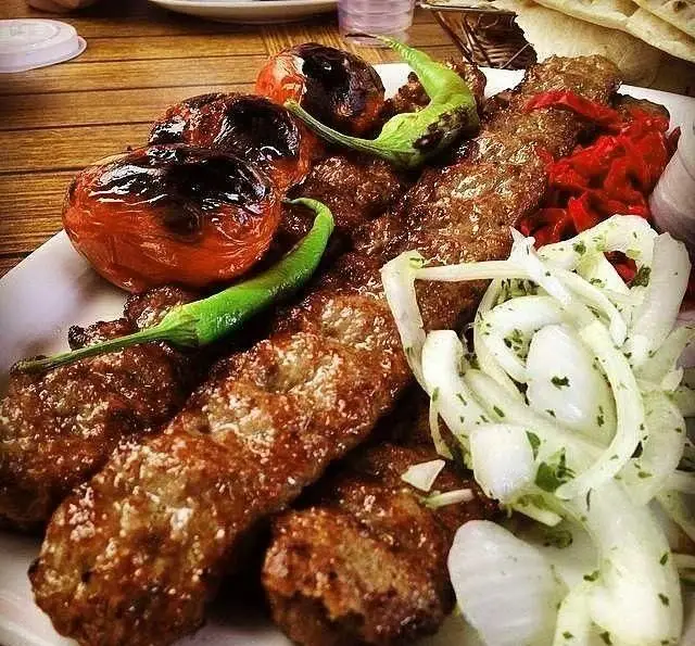 کباب کوبیده لذیذ با گوجه و فلفل کبابی، سالاد پیاز جعفری و نان داغ از رستوران توچال کباب. طعم اصیل ایرانی.
