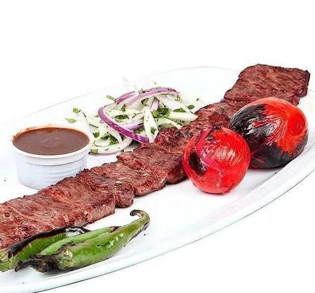 کباب گوشت آبدار رستوران توچال کباب با گوجه و فلفل کبابی تازه، همراه پیاز و سس مخصوص. بهترین انتخاب برای غذای ایرانی.