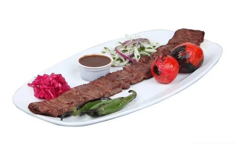 کباب گوشت لذیذ رستوران توچال کباب همراه با گوجه کبابی، فلفل سبز، سس مخصوص، سالاد پیاز و جعفری و کلم قرمز ترش.