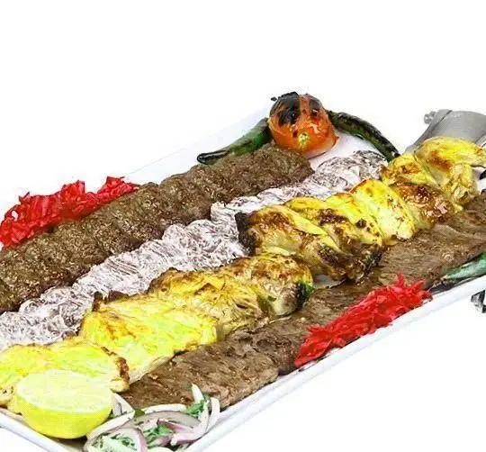 سینی کباب توچال شامل کوبیده، جوجه کباب و کباب برگ، با گوجه، فلفل و لیموترش تازه. بهترین منوی کباب اصیل ایرانی در رستوران توچال کباب.