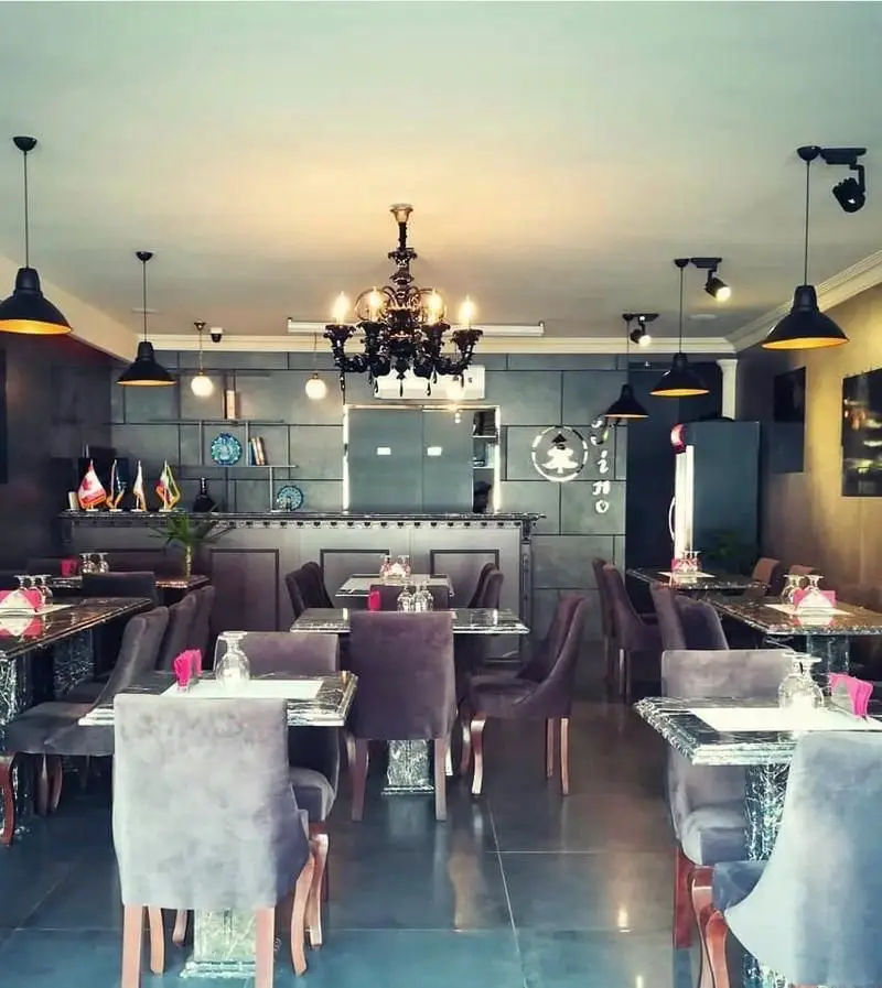 فضای داخلی شیک و مدرن رستوران ایتالیایی پی نو با دکوراسیون جذاب، میز و صندلی‌های مخملی راحت و نورپردازی زیبا.