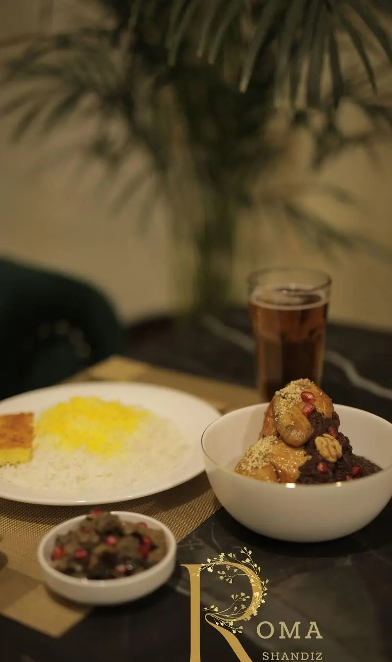 میز غذای لذیذ رستوران شاندیز روما با برنج زعفرانی، ته دیگ، خورش فسنجان یا خوراک ایرانی ویژه و دسر، آماده پذیرایی از شما.