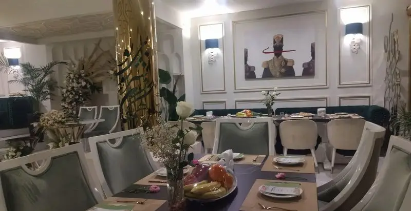 فضای داخلی شیک و لوکس رستوران شاندیز روما با دکوراسیون مدرن، میزهای چیده شده و گل‌آرایی زیبا برای تجربه‌ای خاص.