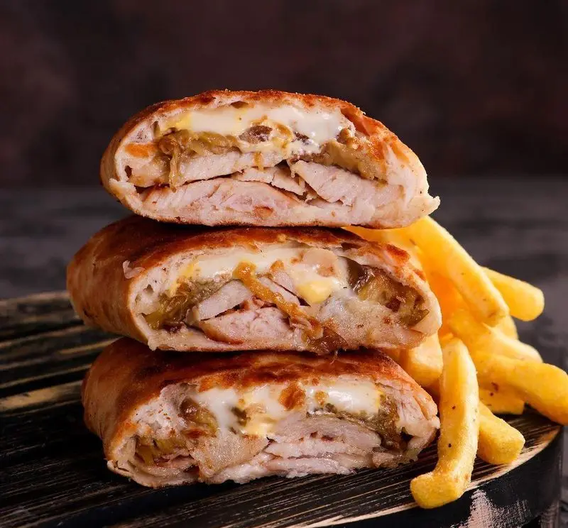 رول مرغ و پنیر خوشمزه و داغ رستوران زنجیره ای شیلا شعبه سهروردی شمالی، با برش های مرغ، پنیر آب شده و سیب زمینی ترد.