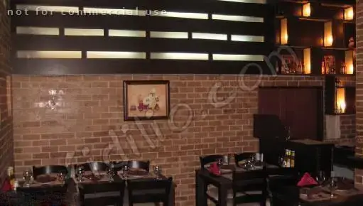 دکوراسیون داخلی رستوران ایتالیایی بیسترو با دیوارهای آجری، میز و صندلی‌های چوبی تیره و نورپردازی دلنشین برای تجربه‌ای خاص.