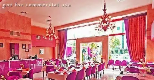 فضای داخلی شیک و مدرن رستوران ستارگان شاندیز فرمانیه با چیدمان زیبای میز و صندلی و دکوراسیون جذاب صورتی و نارنجی.