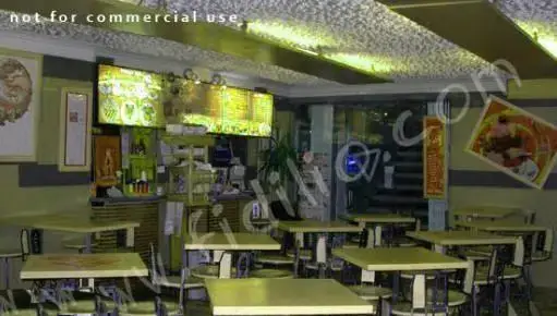 فضای داخلی آرام و دلنشین رستوران پیتزا لاوین، با میز و صندلی‌های منظم و منوهای نورانی روی دیوار، محیطی عالی برای صرف غذا.