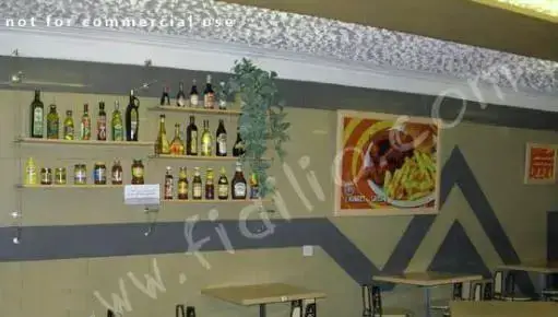 نمایی از فضای داخلی رستوران فست فود پیتزا لاوین با قفسه‌های سس و چاشنی، پوسترهای جذاب غذا و محیطی دلنشین برای صرف غذا.