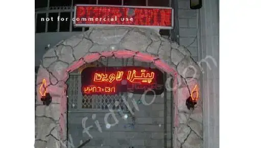 نمای بیرونی پیتزا لاوین، شامل یک ورودی سنگی با طاق، تابلوی نئون روشن "پیتزا لاوین" و شماره تلفن، محیطی دعوت‌کننده برای تجربه طعم پیتزا.