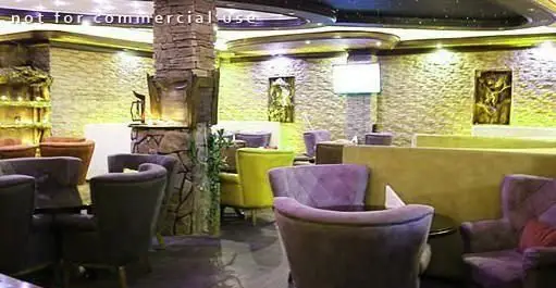 نمای داخلی زیبا و دنج کافه رستوران دل فارو، شامل مبلمان راحتی شیک، دیوارهای سنگی با بافت خاص و نورپردازی گرم و دلپذیر.