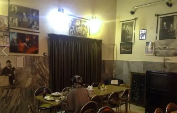 فضای داخلی دنج و دلنشین رستوران آلونک با میزها، صندلی‌ها و تزئینات کلاسیک دیوارها، آماده پذیرایی از مشتریان.