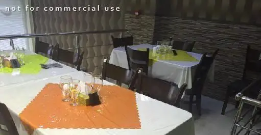 فضای داخلی و دکوراسیون شیک رستوران ایرانی اکبرجوجه ملل، با میز و صندلی‌های مرتب و رومیزی‌های رنگی، محیطی ایده‌آل برای صرف غذا.