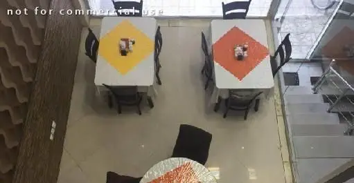 نمای هوایی از فضای داخلی رستوران ایرانی اکبرجوجه ملل با میز و صندلی‌های مرتب و دکوراسیون دلنشین، آماده پذیرایی از مشتریان.