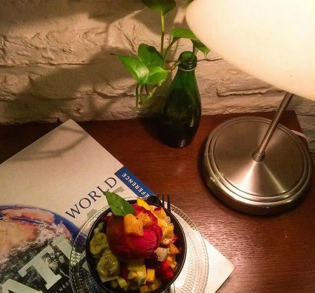 دسر میوه تازه با بستنی در فضای دنج کافه مان و رو، ایده‌آل برای مطالعه و لذت بردن از لحظات آرامش‌بخش.