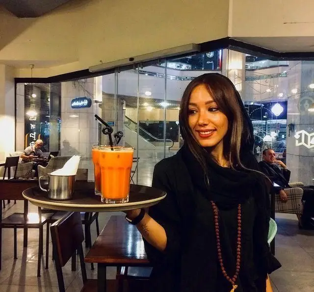 خدمتکار خوش‌رو و شاد در کافه مان و رو، نوشیدنی‌های خنک و گوارای آب پرتقال را برای مهمانان سرو می‌کند. فضایی دلپذیر برای شما.