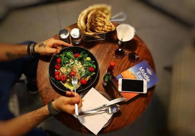 نمایی از میزی پر از صبحانه‌ای لذیذ در کافه مان و رو، شامل سالاد تازه، املت و نان داغ. لحظاتی دلپذیر در کافه