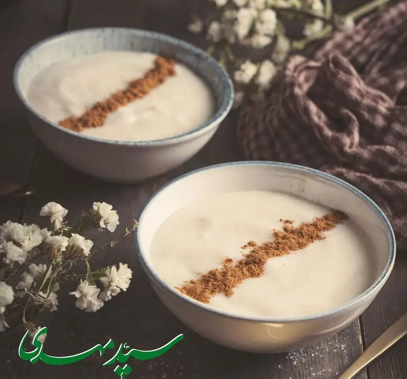 دو کاسه حلیم گرم و لذیذ کسب و کار حلیم و آش سید مهدی، تزئین شده با دارچین، غذایی سنتی و مقوی برای صبحانه.