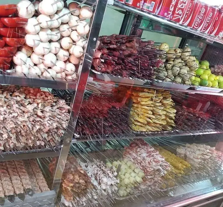 ویترین پر از انواع جگر، کباب گوشت، چنجه، کوبیده، جوجه، قارچ و سیب‌زمینی روی سیخ در جگرسرای شب نشین، آماده طبخ برای لذت مشتریان.