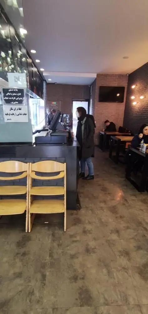 نمای داخلی شلوغ فست فود باروژ با پیشخوان سفارش، میزهای غذاخوری و مشتریان در حال لذت بردن از غذا در فضایی دوستانه.