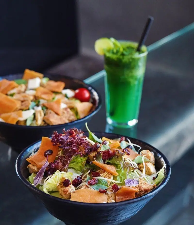 سالادهای ویژه فست فود باروژ با میوه خشک، نان تست و سبزیجات تازه، در کنار یک نوشیدنی سبز خنک و گوارا.