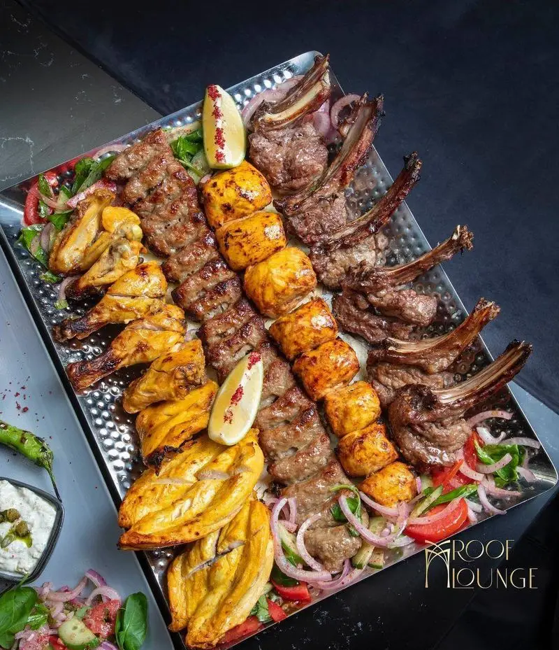 سینی میکس کباب کافه رستوران روف لانژ شامل شیشلیک، کباب کوبیده، جوجه کباب و جوجه حلزونی با نان داغ. یک غذای لذیذ.