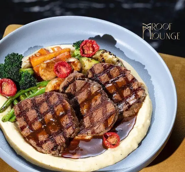 بشقاب استیک فیله گریل شده با رد گریل واضح، همراه پوره، بروکلی، هویج، لوبیا سبز و سس مخصوص در روف لانژ کافه.