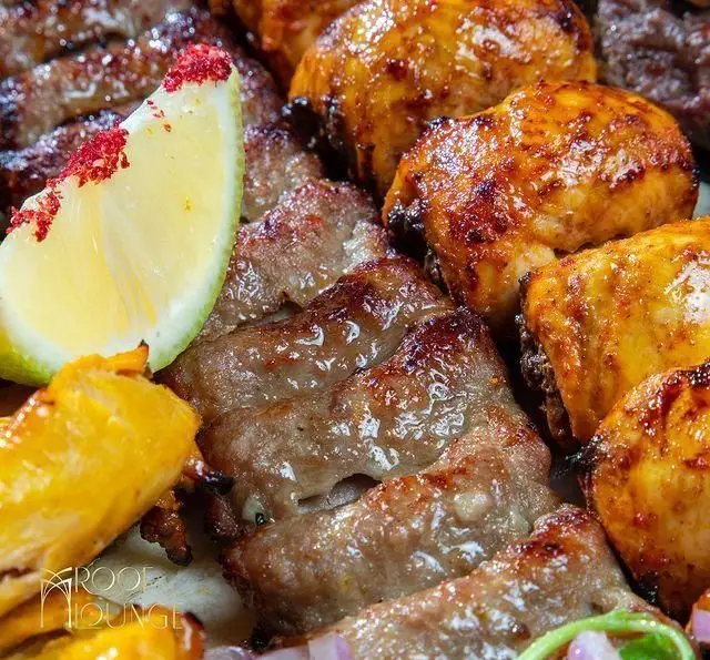 عکس نزدیک از کباب کوبیده و جوجه کباب گریل شده خوشرنگ و لذیذ با چاشنی لیمو و سماق در منوی کافه رستوران روف لانژ.