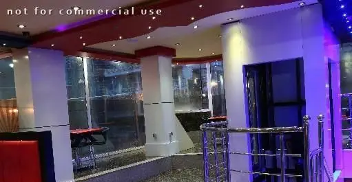 فضای داخلی مدرن و جذاب فست فود شایلی با دکوراسیون شیک، نورپردازی بنفش و میز و صندلی‌های راحت برای مشتریان.