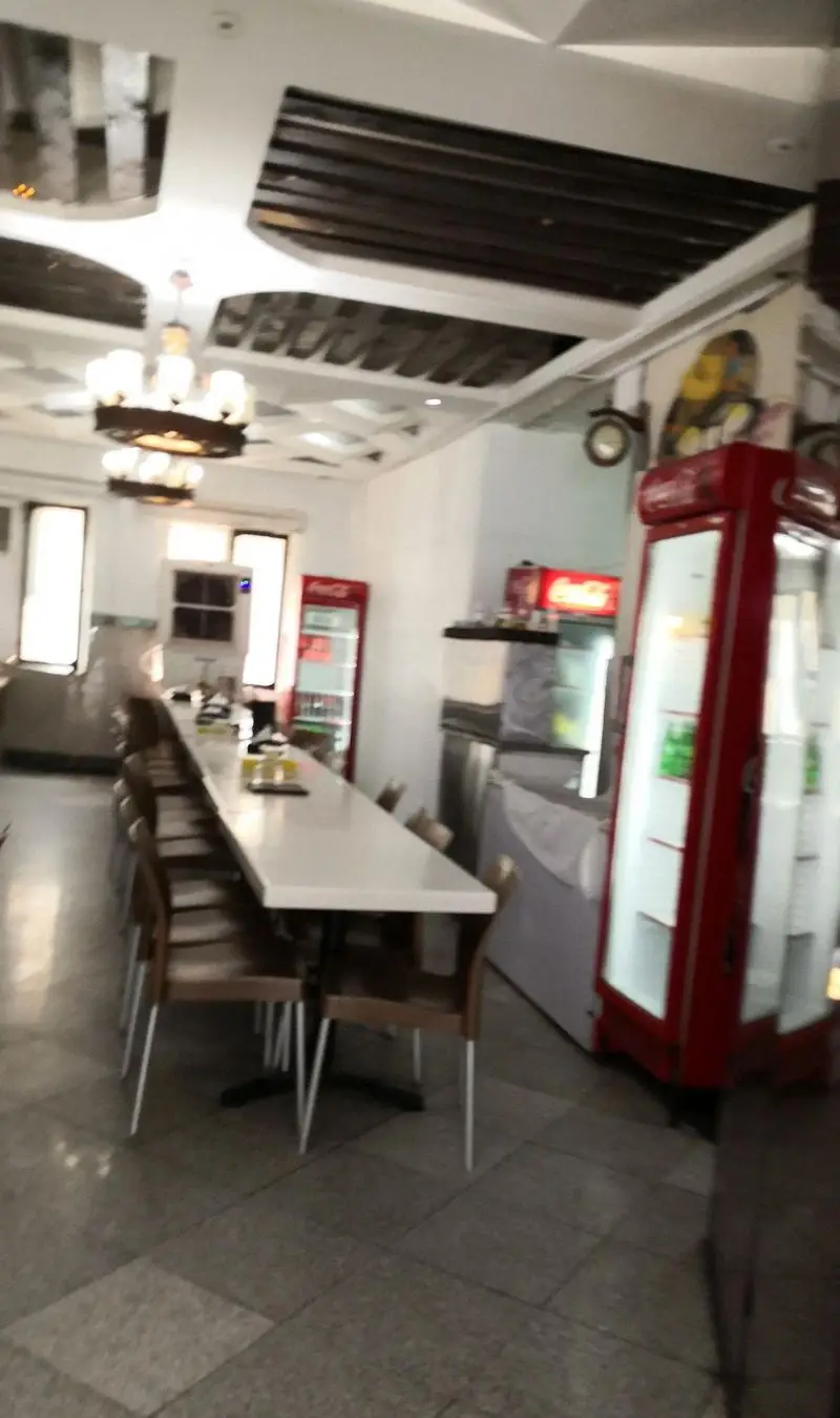 فضای داخلی وسیع و تمیز طباخی کاج، ایده‌آل برای سرو کله‌پاچه و نوشیدنی، با میزهای بلند و یخچال‌های مدرن برای مشتریان.