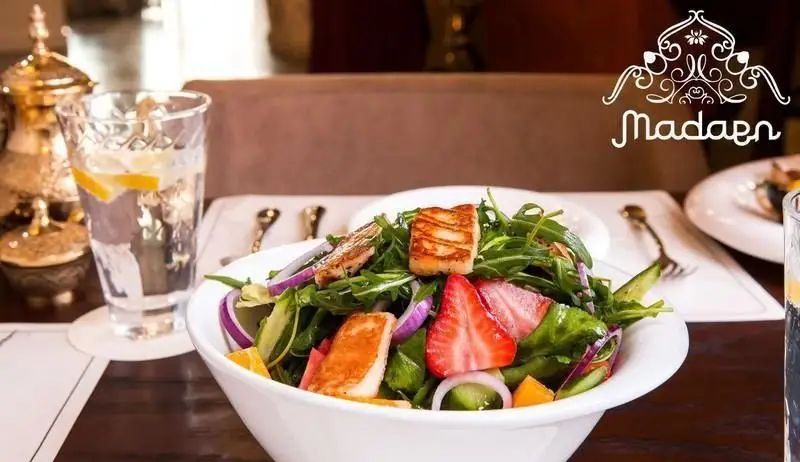 سالاد حالومی و توت فرنگی تازه در کافه رستوران عربی مدائن؛ تجربه غذایی سالم با دکوراسیون شیک و نوشیدنی گوارا.