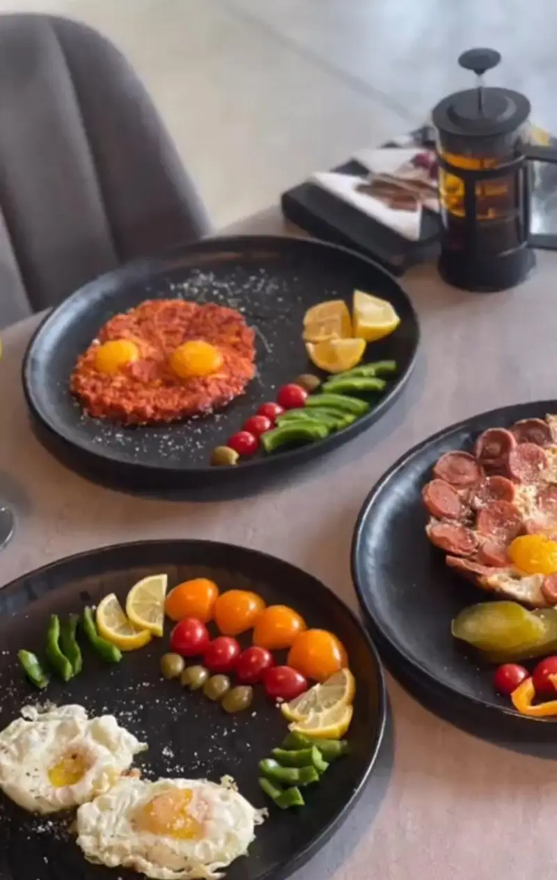 تجربه صبحانه لذیذ در کافه بیلیارد پلن بی: سه بشقاب متنوع شامل نیمرو، املت و سوسیس تخم مرغ با دورچین سبزیجات.