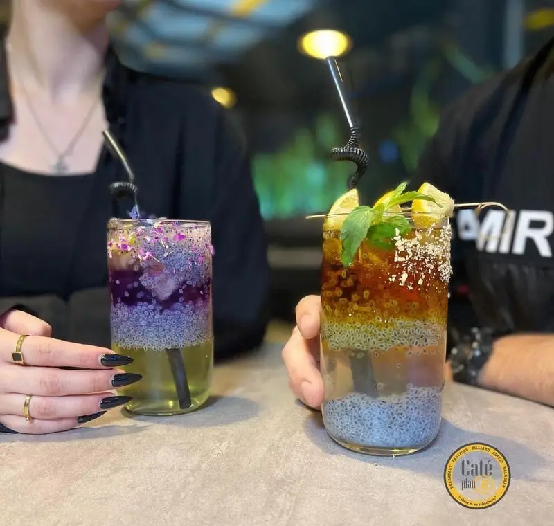 تصویری از دو نوشیدنی تخم شربتی خنک و رنگارنگ در کافه بیلیارد پلن بی، ایده‌آل برای لذت بردن از لحظات دلنشین.