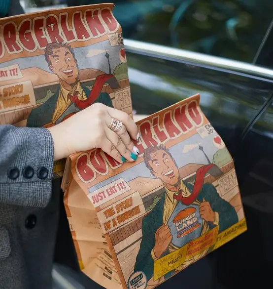 دو پاکت غذای بیرون بر فست فود برگر لند با طراحی کمیک جالب مرد برگر لند؛ آماده سرو همبرگرهای خوشمزه و تازه.