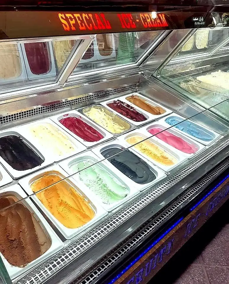 ویترین رنگارنگ بستنی و فالوده شب نشین، ارائه دهنده دسرهای خنک و خوشمزه ویتامینه با طعم‌های متنوع و جذاب.