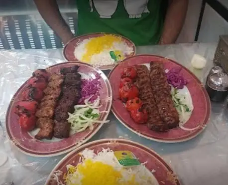 چندین پرس کباب کوبیده، کباب برگ و جوجه کباب همراه برنج زعفرانی و گوجه کبابی، آماده سرو در رستوران محمد.