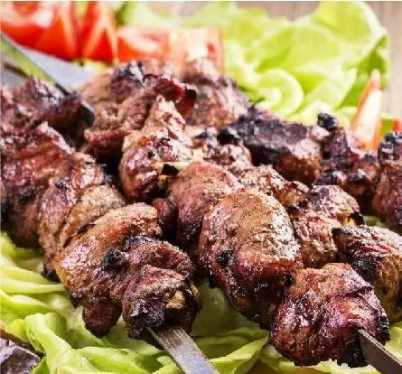 کباب چنجه خوشمزه و آبدار کبابخانه دوزلی شعبه صادقیه، آماده سرو روی بستر کاهو و گوجه فرنگی تازه. لذت طعم اصیل ایرانی.